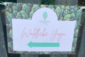 Schild mit Aufschrift Waldliebe Yoga