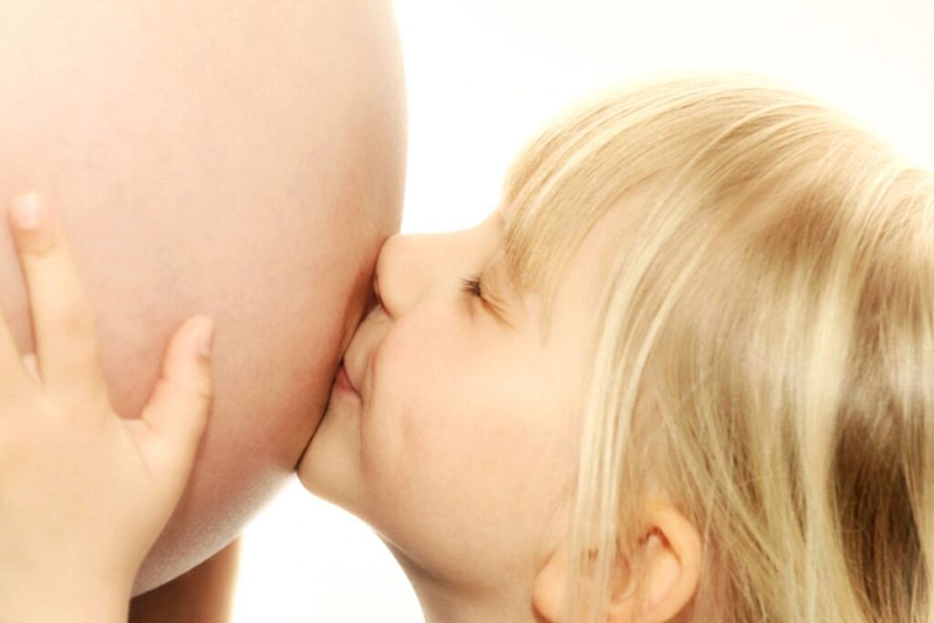 Kind küsst Schwangerschaftsbauch
